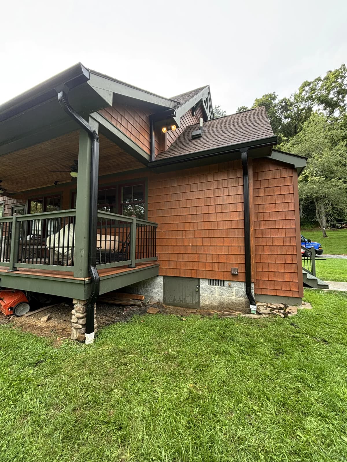 Cedar-shake home with a new dark seamless gutter system installed by Flag Gutter