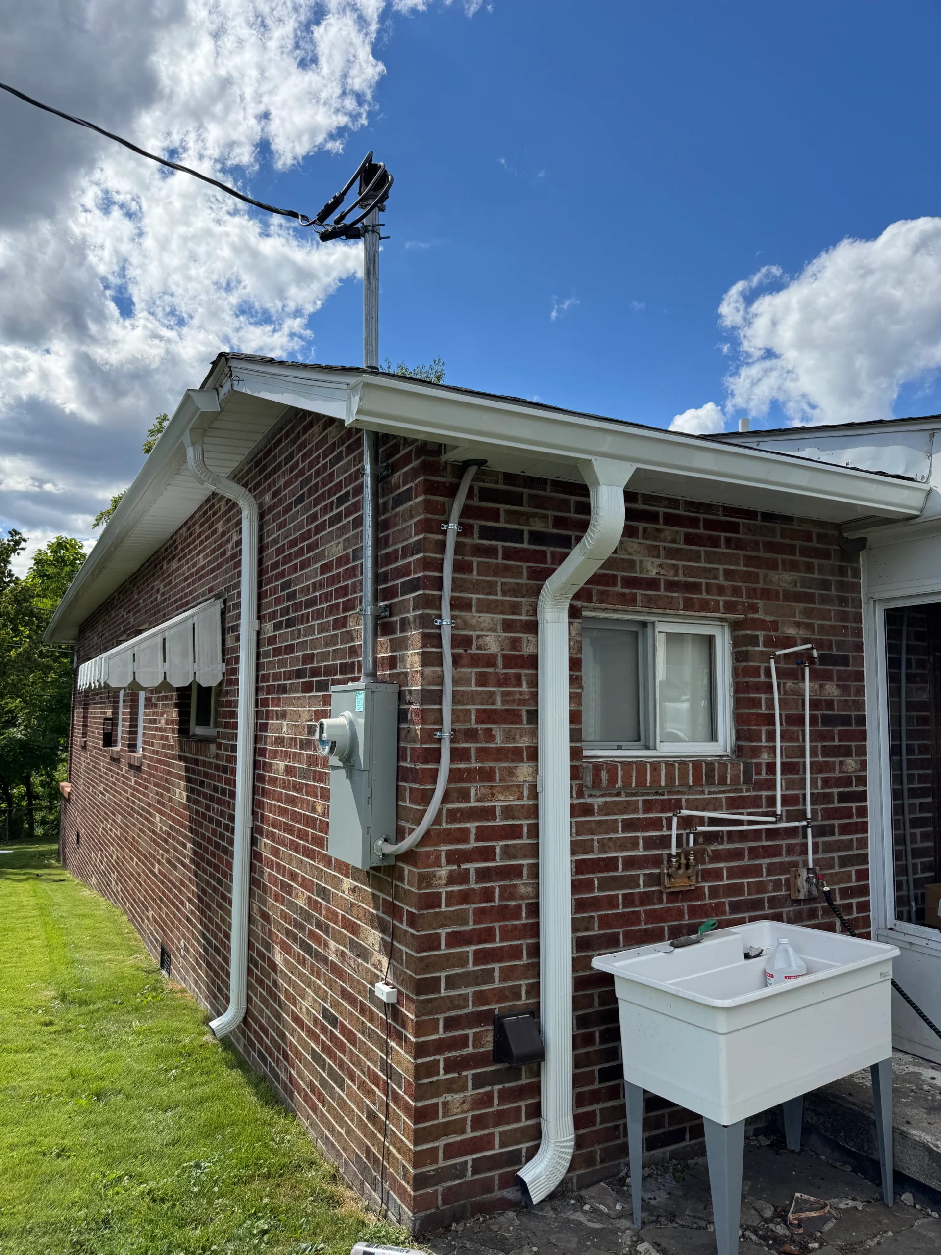 gutter cleaning service in progress with workers using equipment to clear debris ensuring proper drainage and maintenance for homes