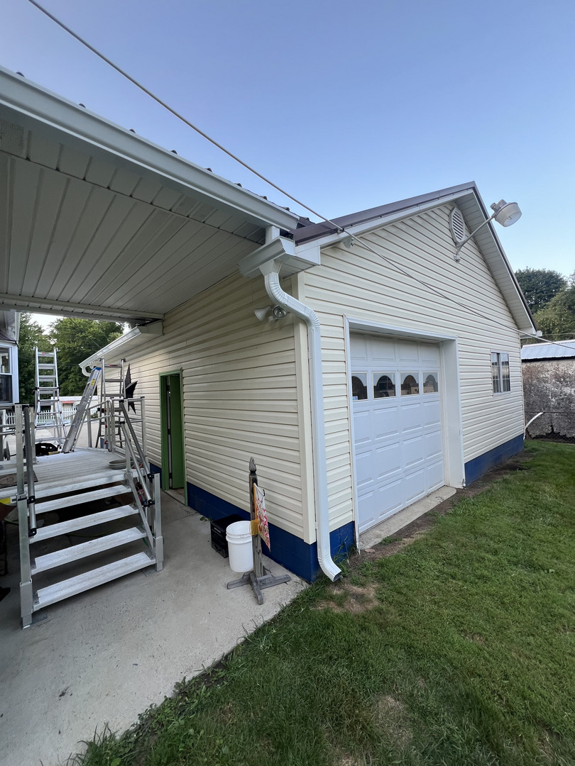 gutter installation on a house with a focus on the downspout and seamless transitions along the siding