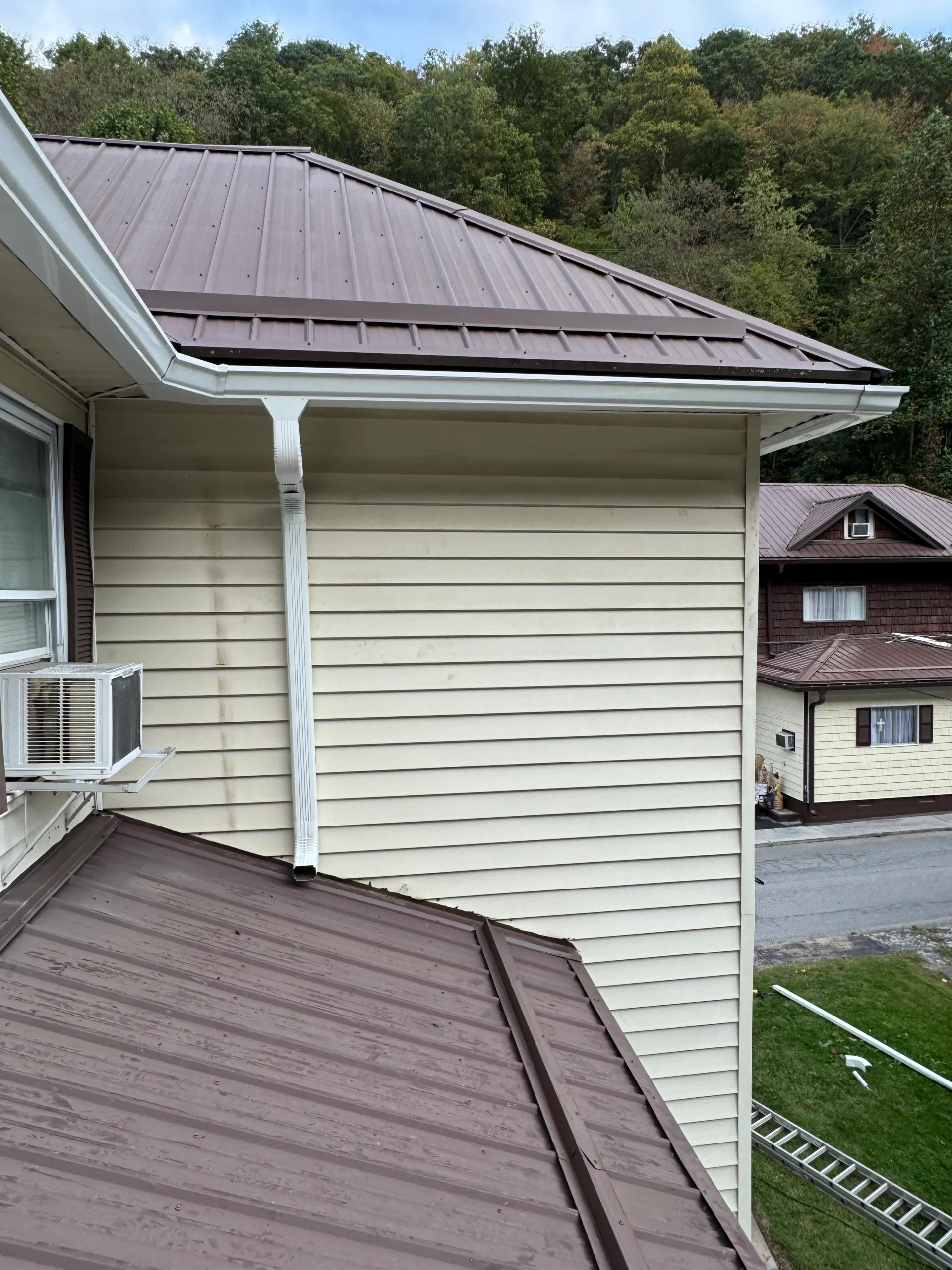 gutter cleaning service in progress with workers removing debris ensuring proper drainage and maintenance for homes in west virginia